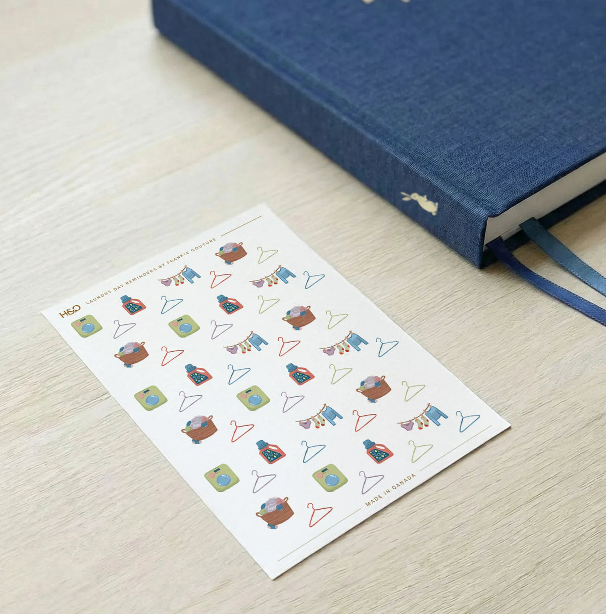 Laundry Day Reminders sticker sheet by Frankie Couture shown with a notebook